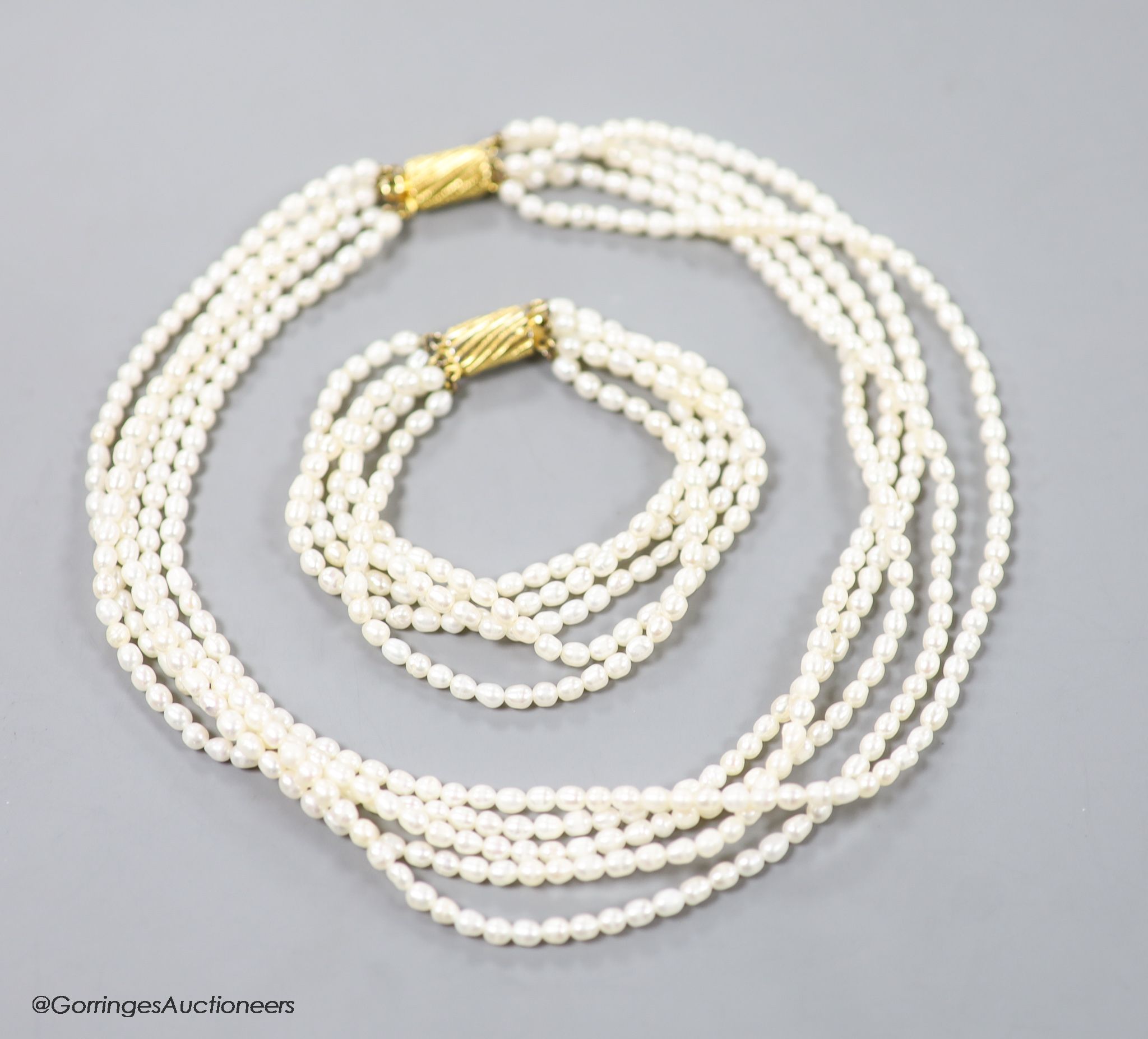 A modern multi strand cultured pearl necklace, with gilt metal clasp, 38cm and a matching bracelet, 17cm.